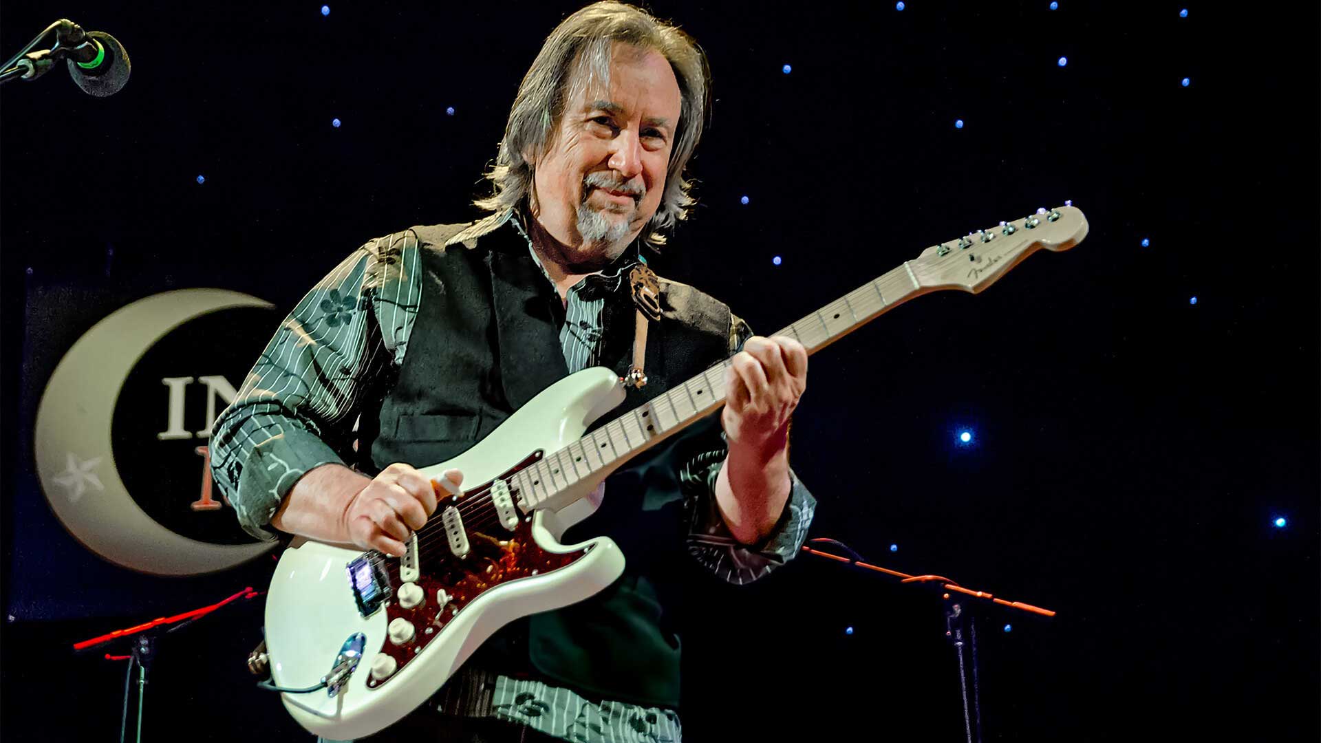 Jim Messina on stage with his guitar, singing folk, rock and country music.